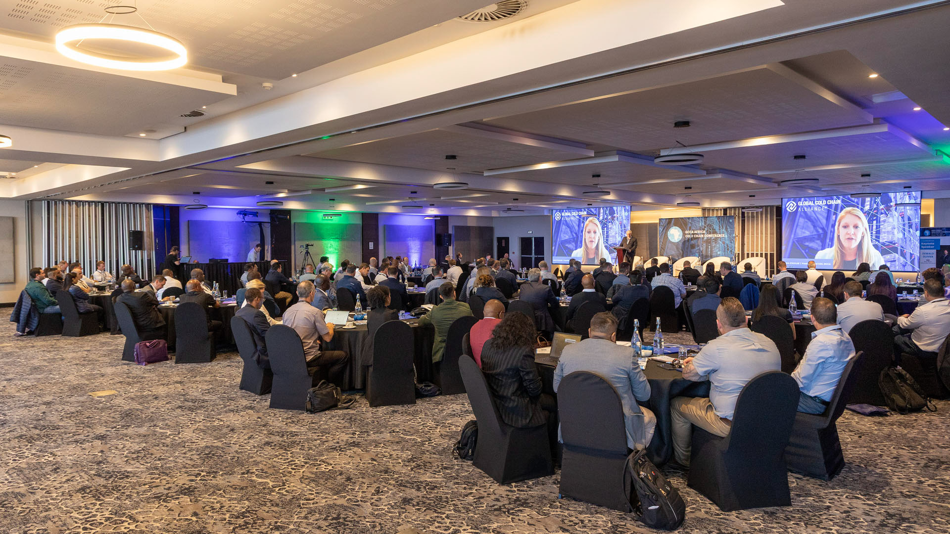 Seamless hybrid event integration showing a remote virtual speaker on screen during the GCCA Durban conference.